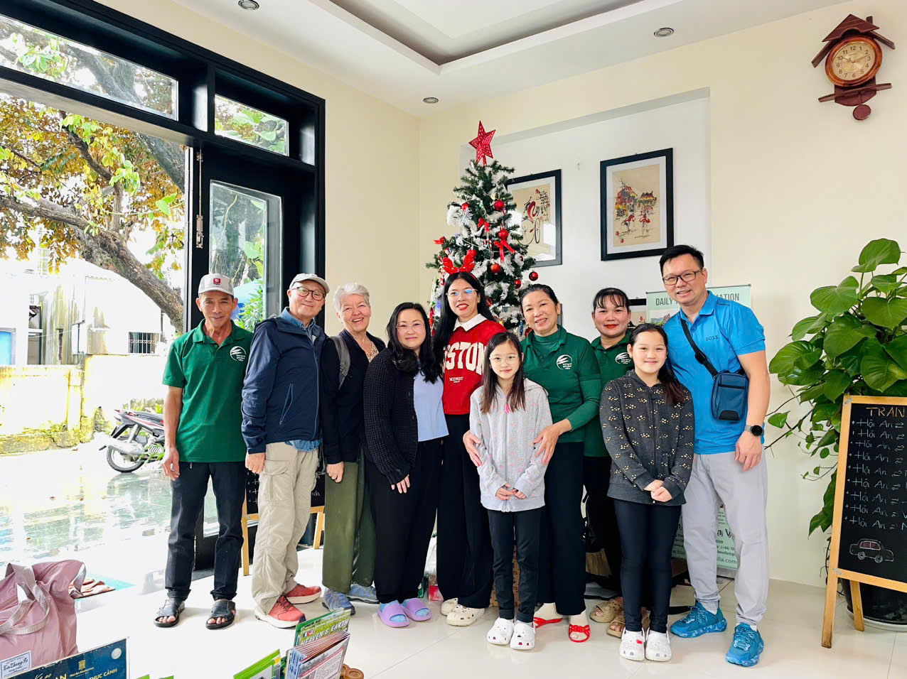 A guest family with staff by the Christmas tree in the lobby